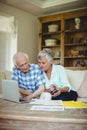 Worried senior couple checking bills in living room Royalty Free Stock Photo