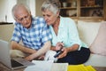 Worried senior couple checking bills in living room Royalty Free Stock Photo