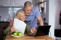 worried senior couple checking finances at home using laptop Royalty Free Stock Photo