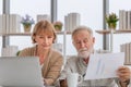 Worried senior couple checking their bills, retired elderly old family reading documents Royalty Free Stock Photo