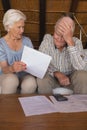 Worried senior couple discussing over medical bills in living room Royalty Free Stock Photo