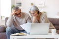 Worried senior family reading financial documents or notification letter with bad news from bank Royalty Free Stock Photo