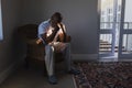 Worried senior man sitting on wicker chair in living room Royalty Free Stock Photo