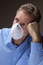 Worried senior man with surgical mask stays at home