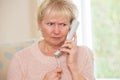 Worried Senior Woman Answering Telephone At Home Royalty Free Stock Photo