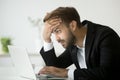 Worried stressed businessman shocked by bad news online using la Royalty Free Stock Photo