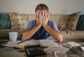 Attractive worried stressed man at home calculating month tax expenses with calculator accounting payments doing bank paperwork in Royalty Free Stock Photo