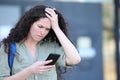 Worried student complaining checking cell phone