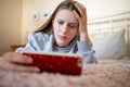 Worried Teenage Girl Lying On Bed With Mobile Phone Being Bullied Online Royalty Free Stock Photo