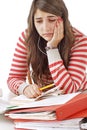Worried teenage girl with piles of school books Royalty Free Stock Photo