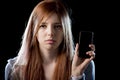 Worried teenager holding mobile phone as internet cyber bullying stalked victim abused Royalty Free Stock Photo