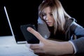 Worried teenager using mobile phone and computer as internet cyber bullying stalked victim abused