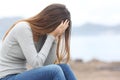 Worried teenager woman on the beach in winter Royalty Free Stock Photo