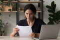 Worried unhappy latin businesswoman read paper letter about credit denial