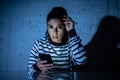 Worried unhappy young woman suffering from cyberbullying and harassment online by mobile phone