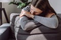 Worried upset Caucasian woman 25s suffering depression feeling lonely, alone at home. Depressed sad young female sitting on sofa Royalty Free Stock Photo