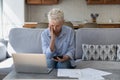 Worried upset middle aged homeowner woman counting expenses
