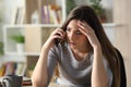 Worried woman calling on phone sitting at home Royalty Free Stock Photo