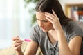 Worried woman checking a pregnancy test