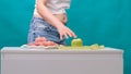 Worried woman with a fat belly should choose between a green apple and a sausage. Dieting concept, beautiful young woman Royalty Free Stock Photo