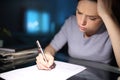 Worried woman filling form in the night at home Royalty Free Stock Photo