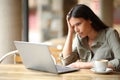 Worried woman finding bad news on laptop