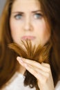 Worried woman looking at her dry hair ends Royalty Free Stock Photo