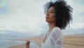 Worried woman looking sea on gloomy day closeup. Thinking african american touch Royalty Free Stock Photo