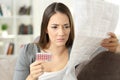 Worried woman reading contraceptive pills leaflet