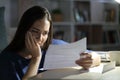 Worried woman reading letter at night at home Royalty Free Stock Photo