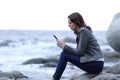 Worried woman reading phone message on the beach Royalty Free Stock Photo