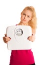 Worried woman standing on scale measuring weight Royalty Free Stock Photo
