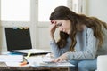 Worried woman suffering stress doing domestic accounting paperwork bills and invoices