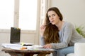 Worried woman suffering stress doing domestic accounting paperwork bills and invoices