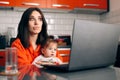 Worried Woman Working a Laptop Holding Her Baby