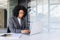 Worried young African American businesswoman working on laptop in office, looking upset at laptop screen Royalty Free Stock Photo