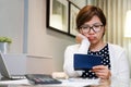 Worried young Asian woman calculating her monthly expenses. Royalty Free Stock Photo