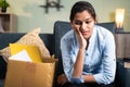 Worried young business woman sitting sadly on sofa at home due to loss of job, employment or fired from the work