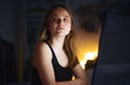 Worried young girl with computer sitting indoors, internet abuse concept.