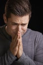 Worried young man with hands clasped, vertical portrait Royalty Free Stock Photo