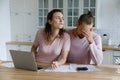 Worried young millennial husband and wife counting overspend budget