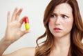 This tablet is way too big. A worried young woman looking at an oversized tablet. Royalty Free Stock Photo