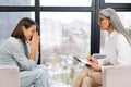 Worried young woman patient sitting at a psychologist's therapist appointment and telling about mental problems Royalty Free Stock Photo