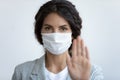 Worried young woman in protective facemask showing stop sign. Royalty Free Stock Photo