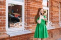 Worried young woman talking on mobile phone standing on city street in summer day, blurred background, selective focus. Royalty Free Stock Photo