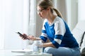 Worried young woman using calculator and counting her savings while sitting on sofa at home Royalty Free Stock Photo