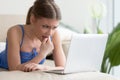 Worried young woman using laptop, feeling nervous passing online Royalty Free Stock Photo