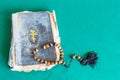 Worry beads and old church book on green table Royalty Free Stock Photo