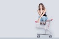 Worry face of asian woman waiting to shopping with sitting on empty shopping cart Royalty Free Stock Photo