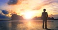 Worship and praise concept: businessman standing by the sea at sunset Royalty Free Stock Photo